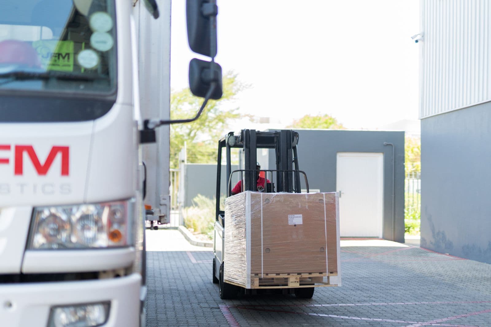Forklift moving a pallet between trucks